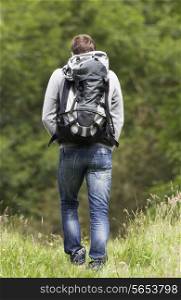 Rear View Of Man Hiking In Countryside