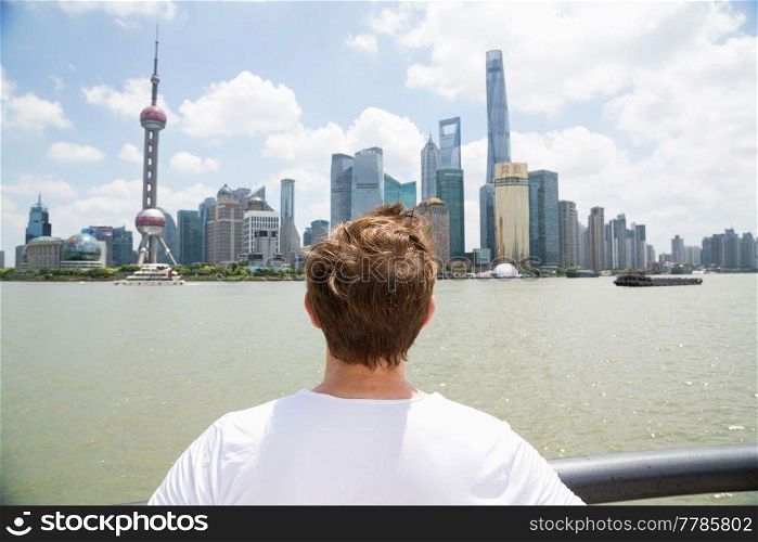 Rear view of man watching Pudong skyline against cloudy sky
