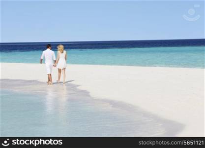 Rear View Of Romantic Couple Walking On Tropical Beach