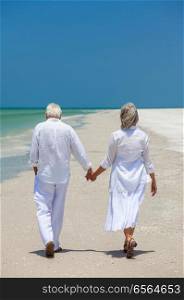 Rear View of Senior Man and Woman Couple Walking Hand in Hand on a Tropical Beach