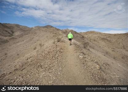 Rear view of senior man jogging on mountain