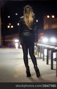 Rear view of sexy woman posing at highway at night