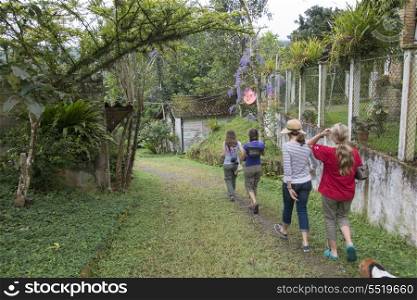 Rear view of tourists walking in a farm, Finca El Cisne, Honduras