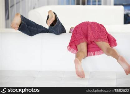 Rear View Of Two Children Playing On Sofa