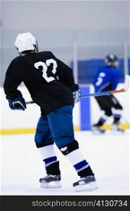 Rear view of two ice hockey players playing ice hockey