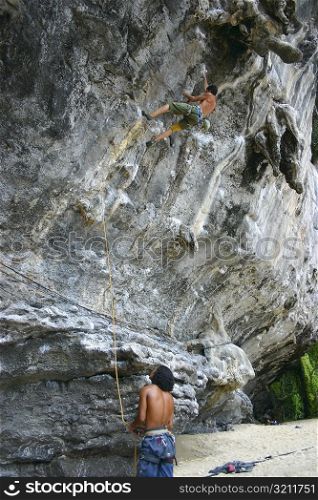Rear view of two mountaineers rock climbing, Phi Phi Islands, Thailand
