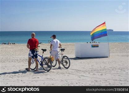 Rear view of two people walking on the beach, South Beach, Miami, Florida, USA