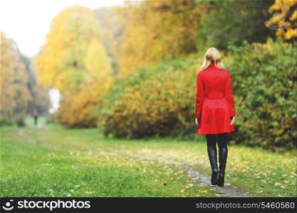 Rear view of walking woman in autumn park