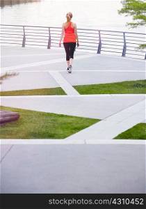 Rear view of woman wearing sports clothing on landscaped urban area