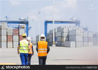 Rear view of workers walking in shipping yard