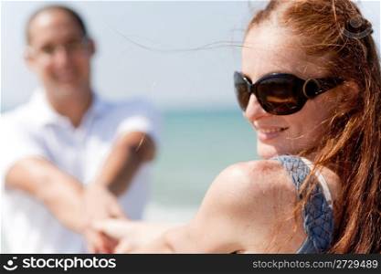 Rear view of young couple sitting at the beach,focusing on woman