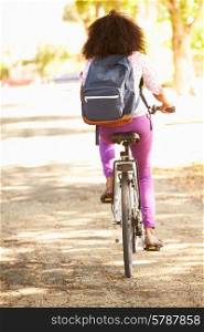 Rear View Of Young Woman Cycling Along Street To Work