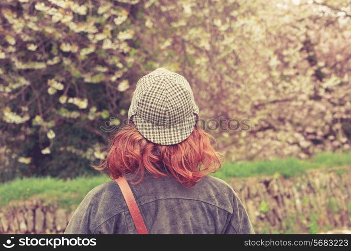 Rear view of young woman in deerstalker hat looking at trees