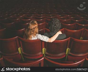 Rear view shot of a young couple sitting in a movie theater