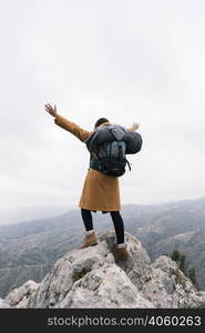 rear view woman raising her arms standing top mountain