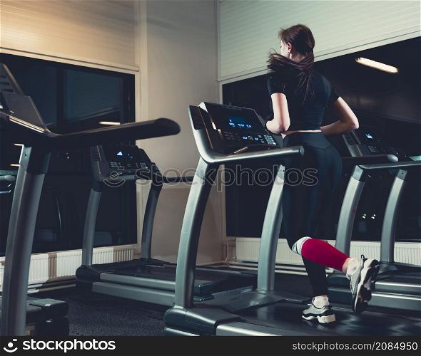 rear view woman running treadmill