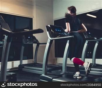 rear view woman running treadmill