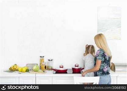 rear view woman with her daughter kitchen