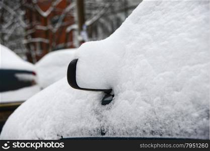 Rearview mirror on a car covered with snow