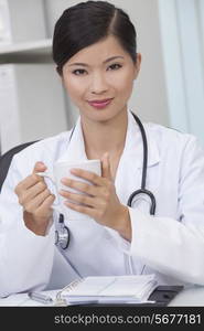 Reassuring Chinese Asian female medical doctor drinking tea or coffee in a hospital office&#xD;