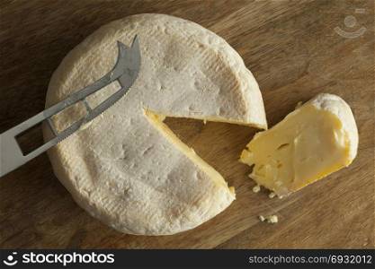 Reblochon de Savoie cheese from raw cows milk with a slice