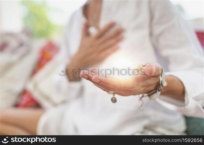 Receiving Energy Hand Gesture. Woman sitting in a lotus position with left palm raised upward to receive positive energy. . Receiving Positive Emotions ? Hand Gesture