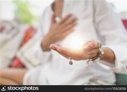 Receiving Energy Hand Gesture. Woman sitting in a lotus position with left palm raised upward to receive positive energy. . Receiving Positive Emotions ? Hand Gesture
