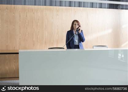 Receptionist talking on telephone in office