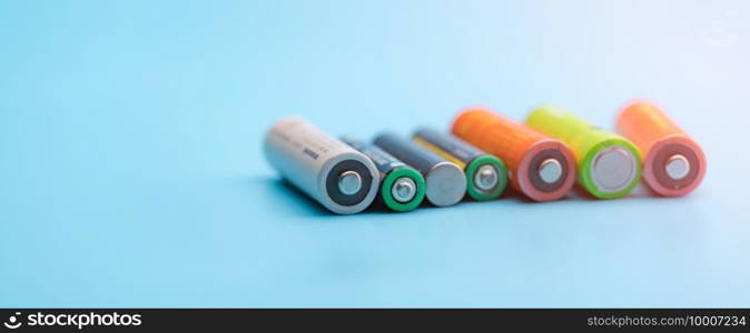 Rechargeable battery on blue background. Selective focus negative terminals of rechargeable lithium-ion batteries. AA and AAA size of old Li-ion battery. Battery recycling concept. Green power energy.