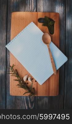 Recipe concept. Blank sheet of paper on a wooden board with spices. The recipe concept