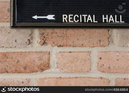 Recital hall sign on brick wall