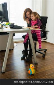 Reconciliation of family and work life. Reconciliation of family and work life: Attractive woman in business attire being distracted by her small daughter sitting on her lap with toy in the foreground