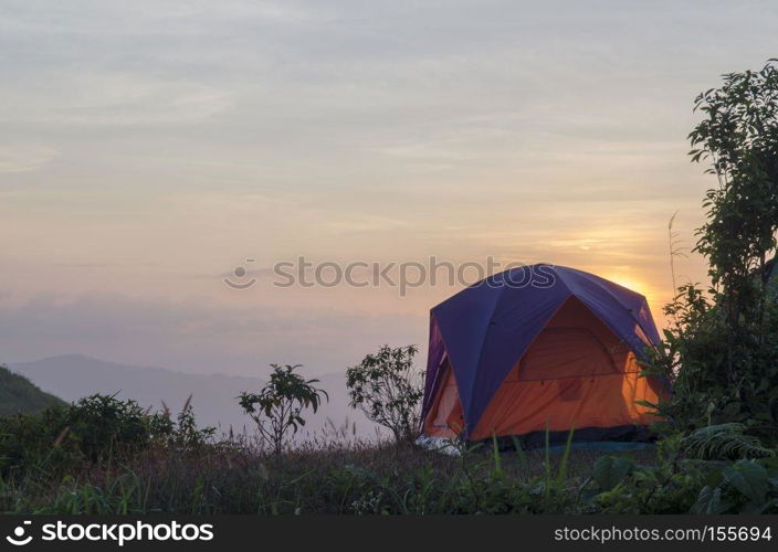 recreation area and camp with tent, sunset time with rising sun near high mountain lake
