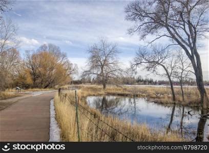 recreational and commuting bike trail along the Poudre River in Fort Collins, Colorado, typical winter scenery with some snow
