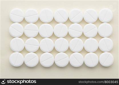Rectangle of white pills on a light background. Rectangle of white tablets on a light background.