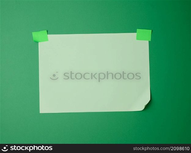 rectangular blank green sheet of paper glued with green sticky paper on green background