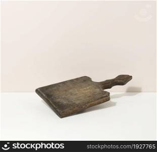 rectangular empty brown wooden kitchen board on a white table, utensils. Place to display food