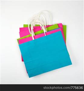 rectangular multi-colored paper shopping bags with handles on a white background, flat lay