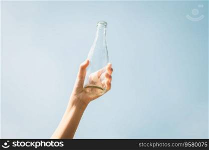 Recyclable glass bottle held in hand up on sky background. Hand holding plastic waste for recycle reduce and reuse concept to promote clean environment with effective recycling management. Gyre. Recyclable glass waste held in hand up on sky background. Gyre