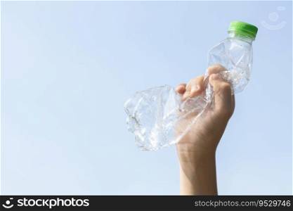 Recyclable plastic bottle held in hand up on sky background. Hand holding plastic waste for recycle reduce and reuse concept to promote clean environment with effective recycling management. Gyre. Recyclable can waste held in hand up on sky isolated background. Gyre