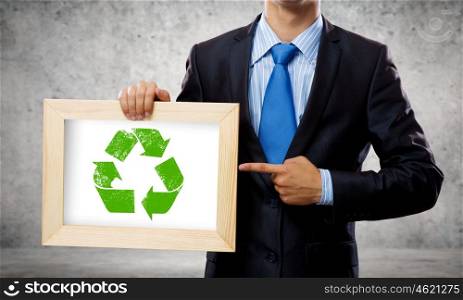 Recycle concept. Close up of businessman holding frame with recycle sign