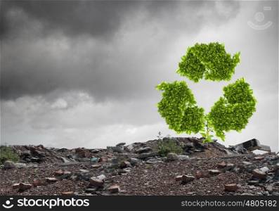 Recycle concept. Conceptual image with recycle green sign growing on ruins