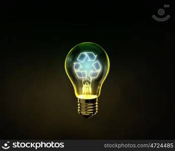 Recycle concept. Glowing lightbulb with recycle symbol inside on dark background