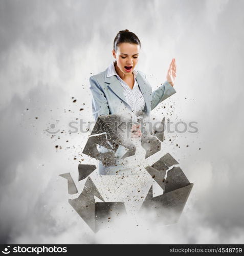 Recycle concept. Image of businesswoman crashing recycle stone symbol