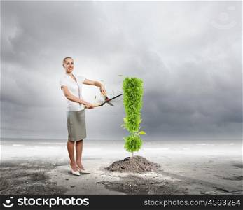 Recycle concept. Young attractive businesswoman cutting plant in shape of exclamation mark