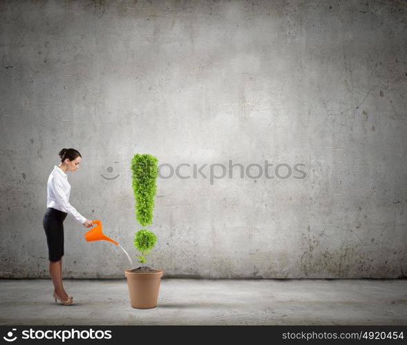 Recycle concept. Young attractive businesswoman watering plant in pot with can