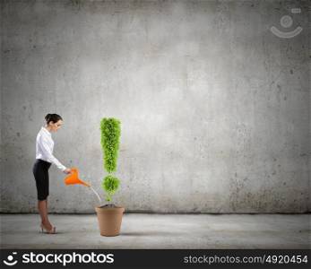 Recycle concept. Young attractive businesswoman watering plant in pot with can