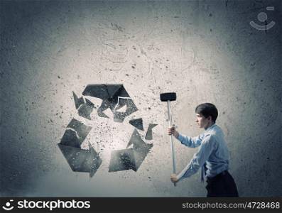 Recycle concept. Young businessman in anger crashing stone recycle symbol