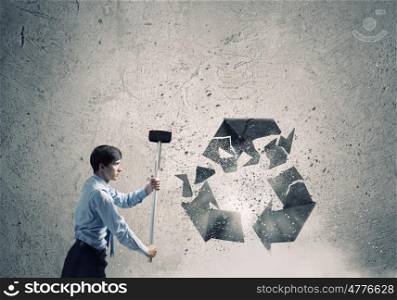 Recycle concept. Young businessman in anger crashing stone recycle symbol