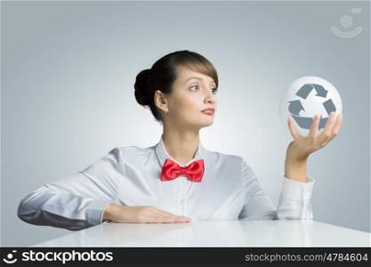 Recycle concept. Young woman holding ball with recycle sign